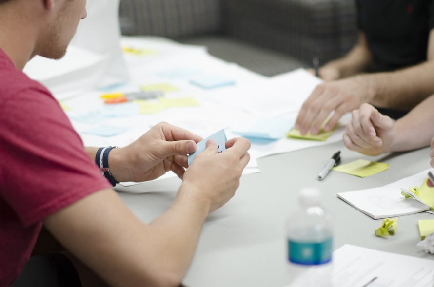 a guy holding a sticky note